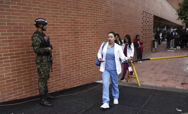 Heath workers arrive to the clinic where Colombian Senator Miguel Uribe Turbay is being treated after he was shot at a political rally in Bogota, Colombia, Monday, June 9, 2025. (AP Photo/Ivan Valencia)