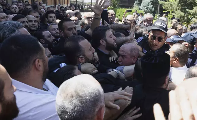 Armenian National Security Service officers clash with parishioners as they arrive to arrest Mikael Ajapahyan, Archbishop of Gyumri and Shirak, at Echmiadzin, the seat of the Armenian Apostolic Church outside Yerevan, Armenia, Friday, June 27, 2025. (Grigor Yepremyan, PAN Photo via AP)