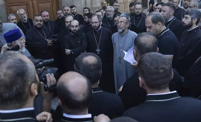 Mikael Ajapahyan, Archbishop of Gyumri and Shirak, center, speaks to other priests as Armenian National Security Service officers arrive to arrest him, at Echmiadzin, the seat of the Armenian Apostolic Church outside Yerevan, Armenia, Friday, June 27, 2025. Catholicos Karekin II is on the left. (Grigor Yepremyan, PAN Photo via AP)
