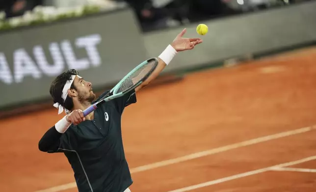 Italy's Lorenzo Musetti serves against Spain's Carlos Alcaraz during their semifinal match of the French Tennis Open at the Roland-Garros stadium in Paris, Friday, June 6, 2025. (AP Photo/Aurelien Morissard)
