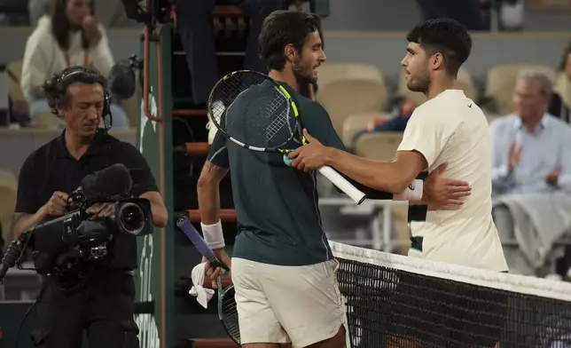 Winner Spain's Carlos Alcaraz, right, and Italy's Lorenzo Musetti greet each other after the semifinal match of the French Tennis Open at the Roland-Garros stadium in Paris, Friday, June 6, 2025. (AP Photo/Christophe Ena)