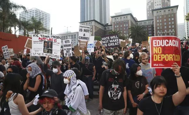 Attendees listen to a speaker during a protest at Pershing Square, Wednesday, June 11, 2025, in Los Angeles. (AP Photo/Ethan Swope)