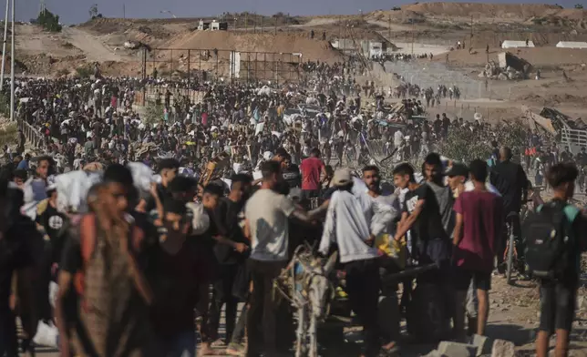 Palestinians carry humanitarian aid packages near the Gaza Humanitarian Foundation distribution center operated by the U.S.-backed organization in Khan Younis, southern Gaza Strip, Thursday, June 26, 2025. (AP Photo/Abdel Kareem Hana)