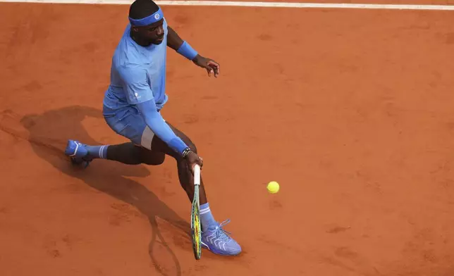 Frances Tiafoe of the U.S. plays a shot against Italy's Lorenzo Musetti during their quarterfinal match of the French Tennis Open at the Roland-Garros stadium in Paris, Tuesday, June 3, 2025. (AP Photo/Thibault Camus)