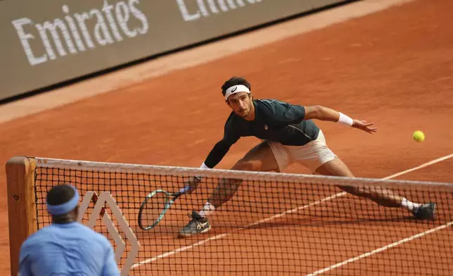 Italy's Lorenzo Musetti, right, plays a shot against Frances Tiafoe of the U.S. during their quarterfinal match of the French Tennis Open at the Roland-Garros stadium in Paris, Tuesday, June 3, 2025. (AP Photo/Aurelien Morissard)