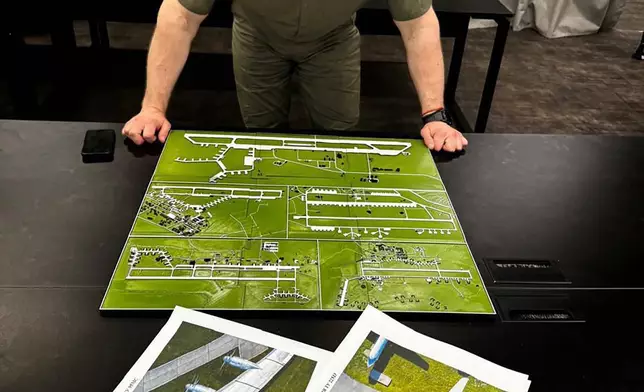 In this undated photo provided by the Ukrainian Security Service, head of the Security Service Vasyl Malyuk studies a photo of a map of Russia's strategic aviation location in his office in Ukraine. (Ukrainian Security Service via AP)
