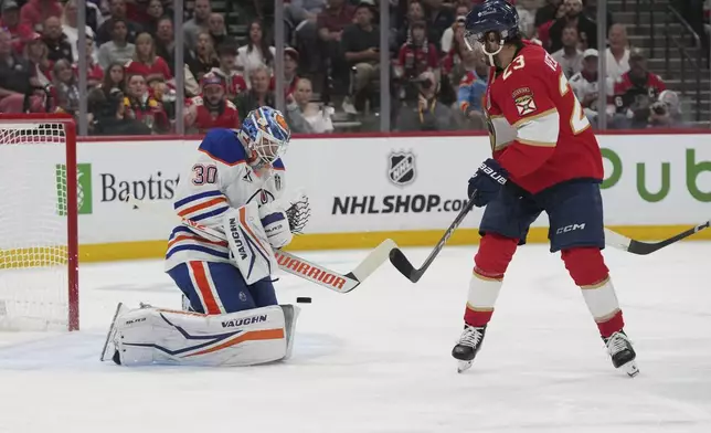 Florida Panthers center Carter Verhaeghe (23) watches as Edmonton Oilers goaltender Calvin Pickard (30) stops a shot on goal during the third period of Game 4 of the NHL hockey Stanley Cup Final Thursday, June 12, 2025, in Sunrise, Fla. (AP Photo/Lynne Sladky)