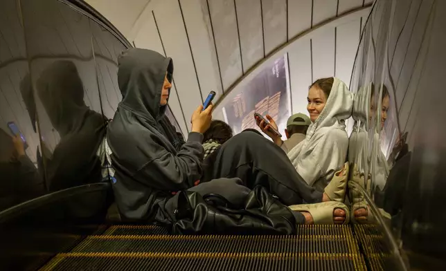 People rest in a metro station, being used as a bomb shelter, during a Russian drones attack in Kyiv, Ukraine, early Tuesday, June 10, 2025. (AP Photo/Dan Bashakov)