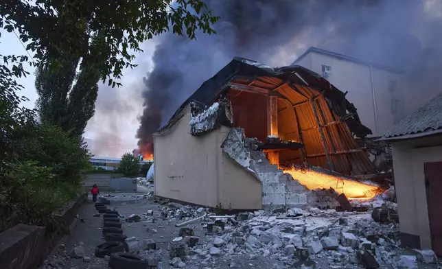 Fire and smoke rise above damaged buildings following Russia's missile and drone attack in Kyiv, Ukraine, Tuesday, June 10, 2025. (AP Photo/Efrem Lukatsky)