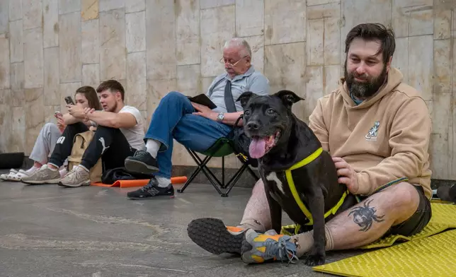 People rest in a metro station, being used as a bomb shelter, during a Russian drones attack in Kyiv, Ukraine, early Tuesday, June 10, 2025. (AP Photo/Dan Bashakov)