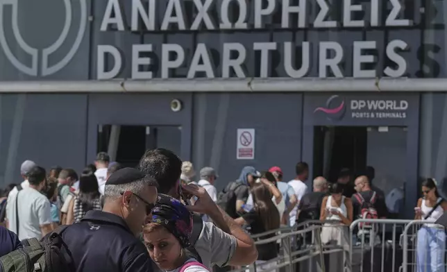 Israelis line up at the entrance to the departures terminal at Cyprus' main port in Limassol where they'll board the Israeli cruise ship Crown Iris to take them back to their homeland, on Thursday, June 19, 2025. (AP Photo/Petros Karadjias)