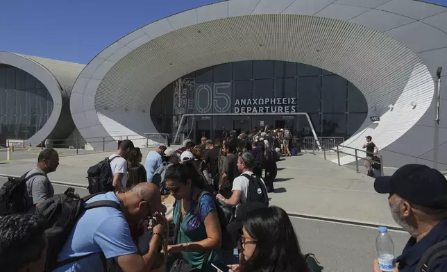 Israelis line up at the entrance to the departures terminal at Cyprus' main port in Limassol where they'll board the Israeli cruise ship Crown Iris to take them back to their homeland, on Thursday, June 19, 2025. (AP Photo/Petros Karadjias)