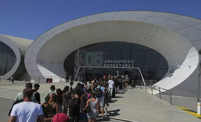 Israelis line up at the entrance to the departures terminal at Cyprus' main port in Limassol where they'll board the Israeli cruise ship Crown Iris to take them back to their homeland, on Thursday, June 19, 2025. (AP Photo/Petros Karadjias)