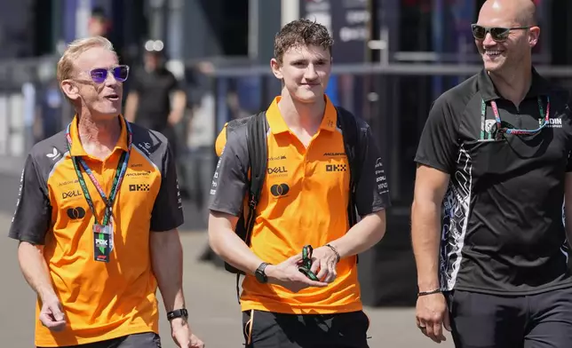 McLaren driver Alexander Dunne of Ireland, centre, walks through the paddock at the Red Bull Ring racetrack, in Spielberg, Austria, Thursday, June 26, 2025, ahead of the Austrian Formula One Grand Prix. (AP Photo/Darko Bandic)