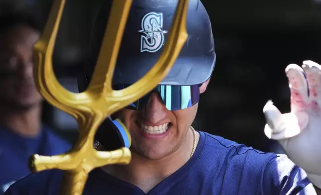 Seattle Mariners' Dominic Canzone celebrates with teammates in the dugout after hitting a solo home run during the second inning of a baseball game against the Chicago Cubs in Chicago, Sunday, June 22, 2025. (AP Photo/Nam Y. Huh)