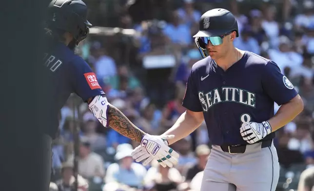 Seattle Mariners' Dominic Canzone, right, celebrates with J.P. Crawford after hitting a solo home run during the sixth inning of a baseball game against the Chicago Cubs in Chicago, Sunday, June 22, 2025. (AP Photo/Nam Y. Huh)