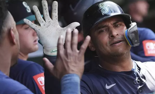 Seattle Mariners' Donovan Solano celebrates with teammates after hitting a two-run home run during the seventh inning of a baseball game against the Chicago Cubs in Chicago, Sunday, June 22, 2025. (AP Photo/Nam Y. Huh)