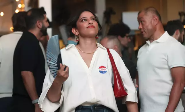 Supporters of Democratic mayoral candidate Zohran Mamdani fan themselves to keep cool as they watch results come in at his primary election party, Tuesday, June 24, 2025, in New York. (AP Photo/Heather Khalifa)