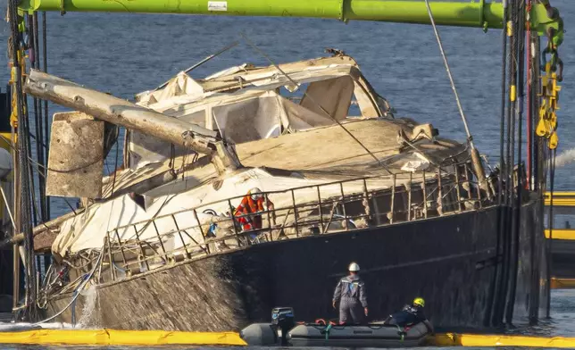 The hull of the superyacht Bayesian, which sank near Palermo, Sicily, on August 19, 2024, is lifted by cranes during salvage operations off the village of Porticello Saturday, June 21, 2025. (AP Photo/Salvatore Cavalli)
