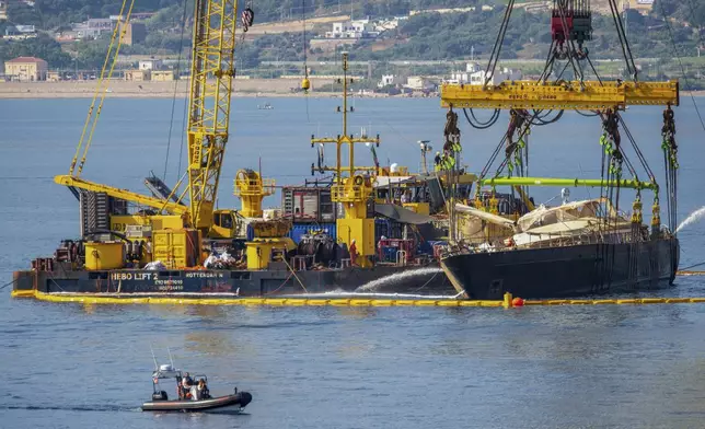 The hull of the superyacht Bayesian, which sank near Palermo, Sicily, on August 19, 2024, is lifted by cranes during salvage operations off the village of Porticello Saturday, June 21, 2025. (AP Photo/Salvatore Cavalli)