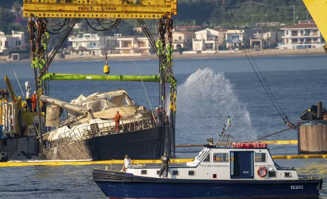 The hull of the superyacht Bayesian, which sank near Palermo, Sicily, on August 19, 2024, is lifted by cranes during salvage operations off the village of Porticello Saturday, June 21, 2025. (AP Photo/Salvatore Cavalli)