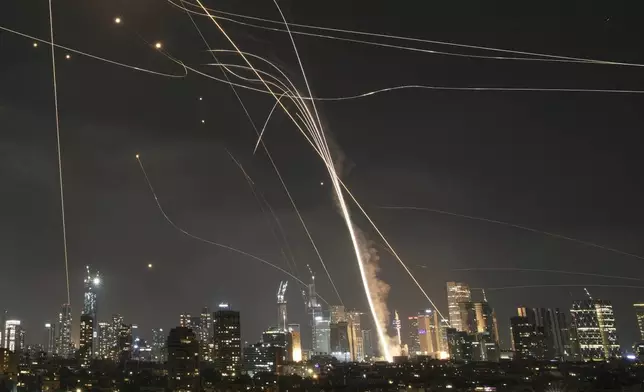 ALTERNATIVE CROP OF XEM124.- A projectile hit buildings as Israeli Iron Dome air defense system fires to intercept missiles over Tel Aviv, Israel, Friday, June 13, 2025. (AP Photo/Leo Correa)