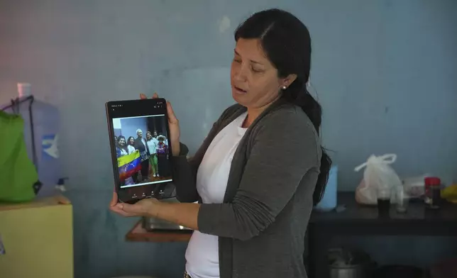 FILE - Venezuelan Betania Rodriguez holds up her tablet to show a group photo taken with Pope Leo XIV, then Bishop Robert Prevost, at a migrant shelter run by Prevost and the Order of St. Vincent de Paul, in Chiclayo, Peru, Saturday, May 10, 2025. (AP Photo/Guadalupe Pardo, File)