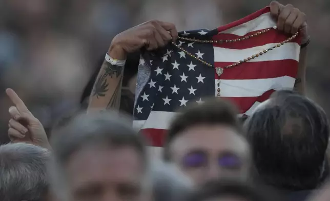 FILE - Faithful holds an American flag following the election of Pope Leo XIV at the Vatican, Thursday, May 8, 2025. (AP Photo/Andrew Medichini, File)