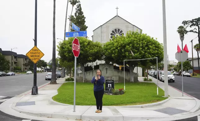 Melyssa Rivas stands at an intersection where she witnessed masked federal agents detaining a person earlier this month outside Our Lady of Perpetual Help Catholic Church in Downey, Calif., on Friday, June 20, 2025. (AP Photo/Damian Dovarganes)