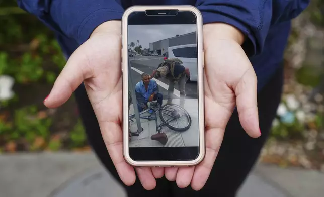 Melyssa Rivas shows her video of masked federal agents detaining a person earlier this month outside Our Lady of Perpetual Help Catholic Church in Downey, Calif., on Friday, June 20, 2025. (AP Photo/Damian Dovarganes)