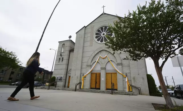 Melyssa Rivas walks outside a location where she witnessed masked federal agents detaining a person earlier this month outside Our Lady of Perpetual Help Catholic Church in Downey, Calif., on Friday, June 20, 2025. (AP Photo/Damian Dovarganes)