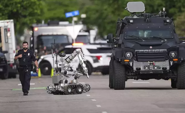 Law enforcement officials investigate after an attack on the Pearl Street Mall Sunday, June 1, 2025, in Boulder, Colo. (AP Photo/David Zalubowski)