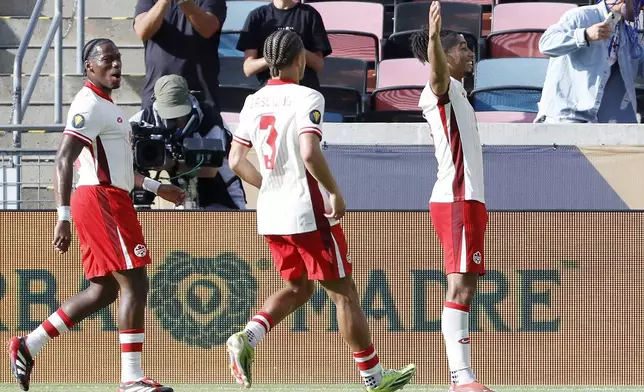 Canada's Nathan Saliba, right, celebrates his goal against Curaca in front of Jonathan David, left, and Zorhan Bassong (3) during a CONCACAF Gold Cup soccer match Saturday, June 21, 2025, in Houston, Texas. (AP Photo/Michael Wyke)