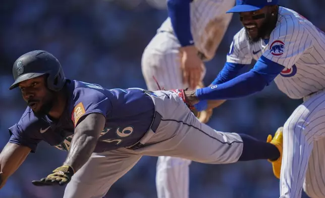 Seattle Mariners' Randy Arozarena (56) gets caught in a rundown between first and second bases and is ultimately tagged out by Chicago Cubs' Vidal Bruján , right, during the seventh inning of a baseball game Saturday, June 21, 2025, in Chicago. (AP Photo/Erin Hooley)
