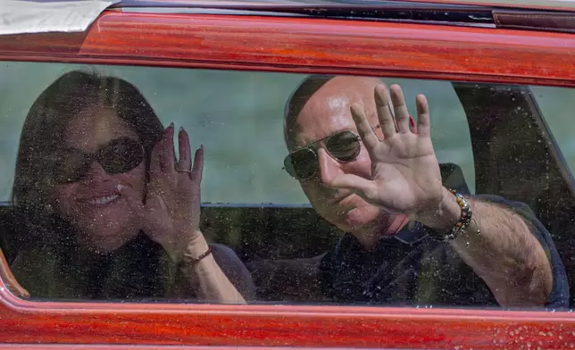 Amazon multi-billionaire founder Jeff Bezos, right, and Lauren Sanchez arrive by boat at a hotel in Venice, Italy, on Wednesday, June 25, 2025, ahead of festivities in the lagoon city reportedly linked to their wedding. (AP Photo/Luca Bruno)