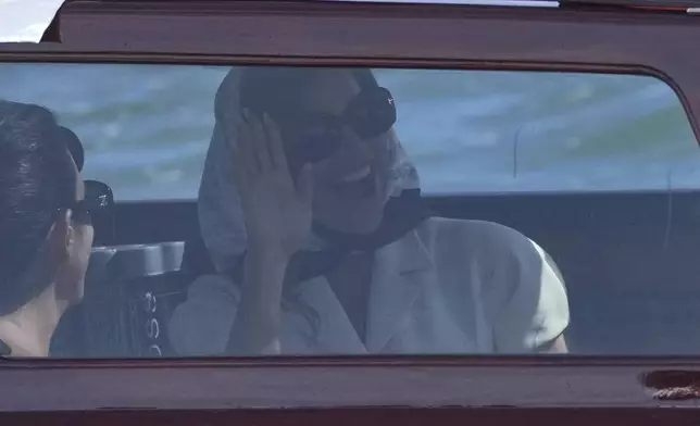 Lauren Sanchez waves from a boat after leaving a hotel ahead of the anticipated wedding celebrations with Jeff Bezos, in Venice, Italy, Friday, June 27, 2025. (AP Photo/Antonio Calanni)