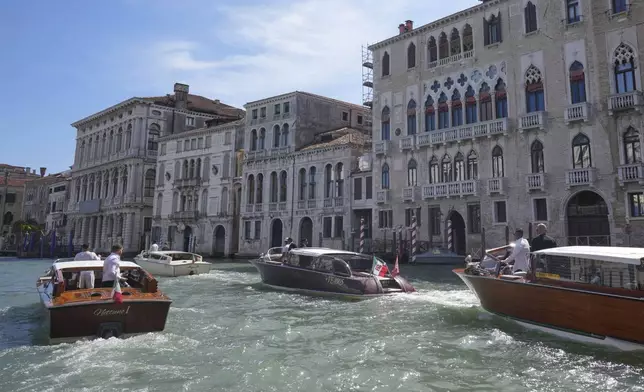 A boat, center, carrying Lauren Sanchez, leaves a hotel ahead of the anticipated wedding celebrations with Jeff Bezos, in Venice, Italy, Friday, June 27, 2025. (AP Photo/Antonio Calanni)