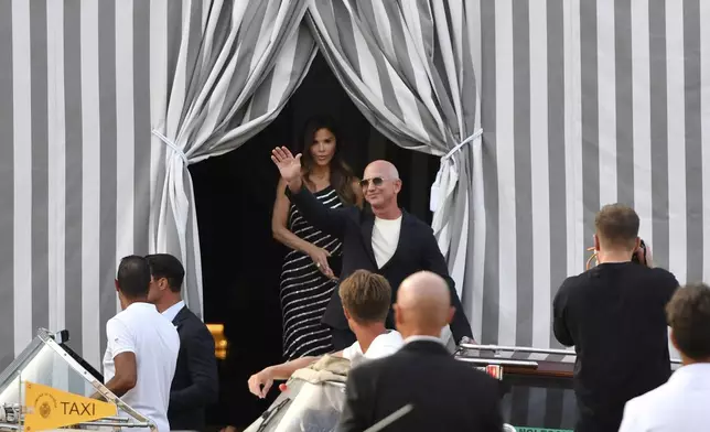 Amazon multi-billionaire founder Jeff Bezos, right, and Lauren Sanchez leave a hotel in Venice, Italy, on Wednesday, June 25, 2025, ahead of festivities in the lagoon city reportedly linked to their wedding. (AP Photo/Luigi Costantini)