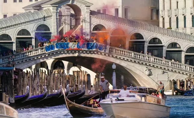 Activists stage a protest on the Rialto Bridge in Venice, Italy, Saturday, June 28, 2025, denouncing the three-day celebrations for the wedding between Jeff Bezos and his wife Lauren Sanchez Bezos that took place in Venice on Friday as a symbol of rising inequality and disregard for the city's residents. (AP Photo/Luca Bruno)