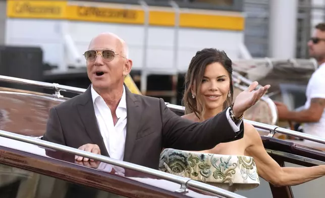 Jeff Bezos, left, and Lauren Sanchez leave their pre wedding reception, in Venice, Italy, Thursday, June 26, 2025. (AP Photo/Luca Bruno)