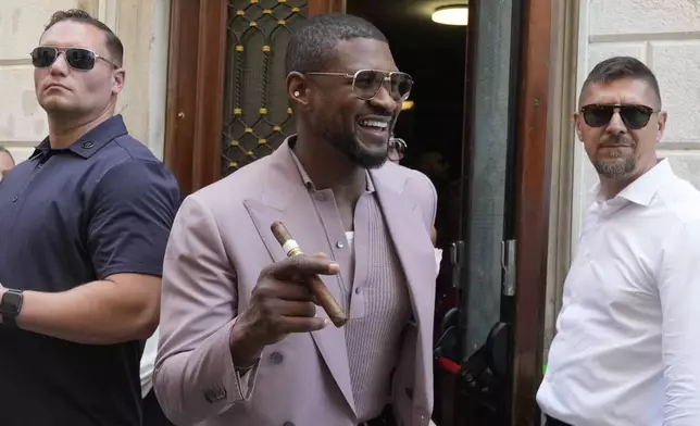 Usher, center, leaves the Harry's Bar in Venice, Italy, Saturday,June 28, 2025. (AP Photo/Luca Bruno)
