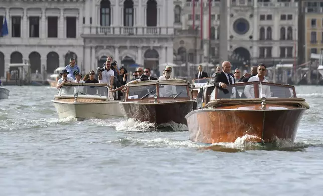 The boat, center, carrying Jeff Bezos travels past St. Mark's Square ahead of the anticipated wedding celebrations of Jeff Bezos and Lauren Sanchez, in Venice, Friday, June 27, 2025. (AP Photo/Luigi Costantini)