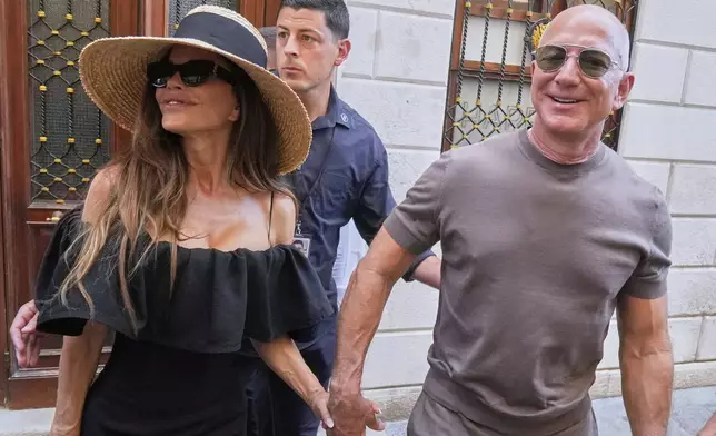 Lauren Sanchez Bezos and Jeff Bezos leave the Harry's Bar in Venice, Italy, Saturday,June 28, 2025, the day after their wedding. (AP Photo/Luca Bruno)