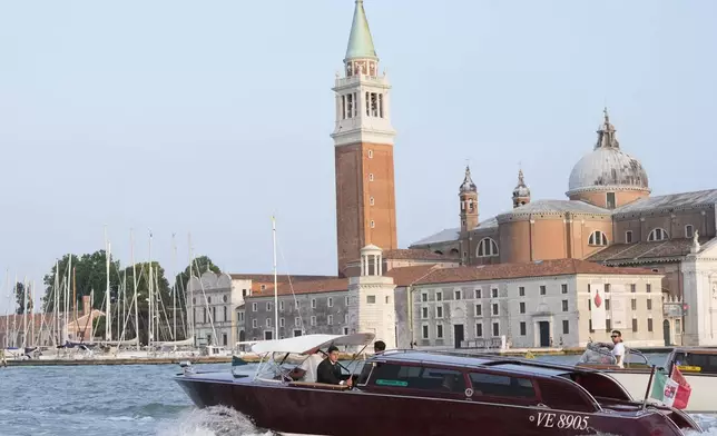 Jeff Bezos and Lauren Sanchez, inside boat, pass by the San Giorgio Maggiore Church on their way to their pre wedding reception, in Venice, Italy, Thursday, June 26, 2025. (AP Photo/Luca Bruno)