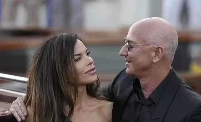 Lauren Sanchez Bezos, left, and Jeff Bezos depart from the Aman hotel during wedding celebrations in Venice, Italy, Saturday, June 28, 2025. (AP Photo/Luca Bruno)