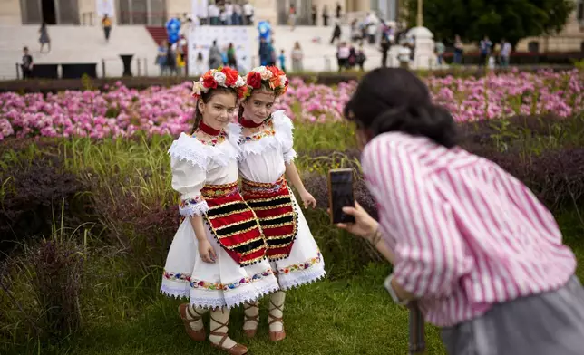 Students of a dance school pose for a photograph outside Romania's Palace of Parliament during a series of events marking International Children's Day in Bucharest, Romania, Sunday, June 1, 2025. (AP Photo/Andreea Alexandru)