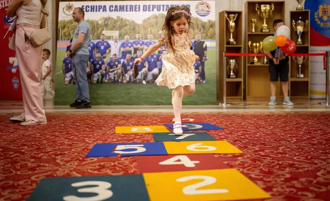 A girl plays inside Romania's Palace of Parliament during a series of events marking International Children's Day in Bucharest, Romania, Sunday, June 1, 2025. (AP Photo/Andreea Alexandru)