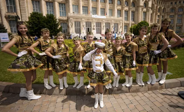Students of a dance school strike a pose outside Romania's Palace of Parliament during a series of events marking International Children's Day in Bucharest, Romania, Sunday, June 1, 2025. (AP Photo/Andreea Alexandru)