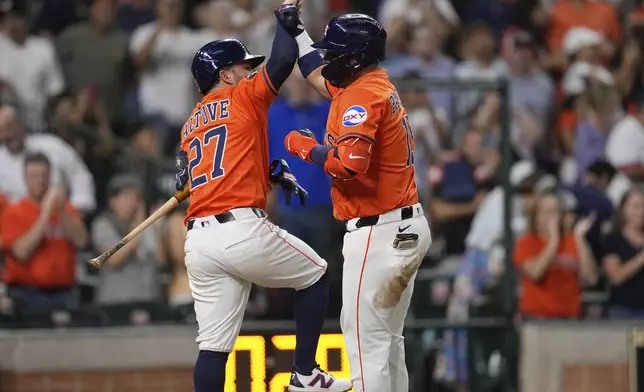 Houston Astros' Isaac Paredes, right, celebrates with Jose Altuve (27) after hitting a home run against the Chicago White Sox during the fifth inning of a baseball game Thursday, June 12, 2025, in Houston. (AP Photo/David J. Phillip)