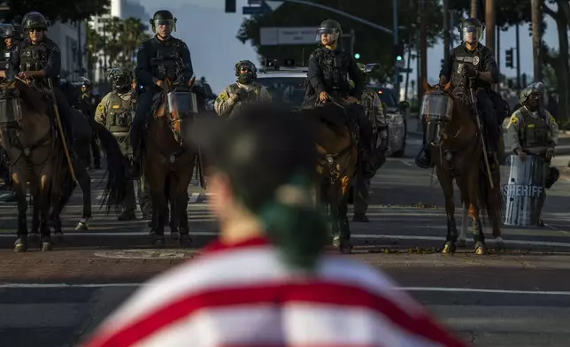 Police confront a protesters outside City Hall during protests over federal immigration enforcement raids on Wednesday, June 11, 2025, in Los Angeles. (AP Photo/Ethan Swope)